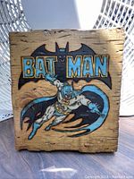 Front view of hand carved and hand painted Batman plaque on wood