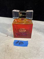 Front view of full Kate Spade Live Color Fully perfume bottle showing gradient orange to red glass and clear rectangular cap.