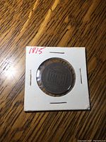 Front view of 1815 half penny coin in protective holder showing the full coin and holder with year '1815' written on casing.