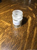 Clear plastic tube containing the nine 1920s nickels, showing storage condition and container.