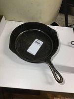 Top angle view of the cast iron frying pan showing the frying surface and handle with pouring spout
