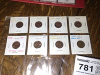 Eight Canadian pennies in individual cardboard holders labeled with error types and years, arranged in two rows of four within a plastic holder.