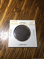 Oblique angle photo of the coin in holder, emphasizing the coin surface and holder details including handwritten notes indicating year 1858 and grade VF.