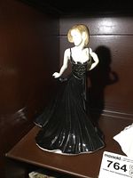 Front view of the Royal Doulton Amelia figurine in a black dress with blonde hair, showing the front details and pose.
