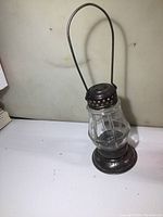 Full view of vintage skaters lantern, showing metal handle, ventilated metal top, faceted glass body, and metal base.