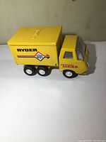 Side profile of the yellow Tonka box truck showing Ryder and One Way decals on the cargo box and Tonka decal on the cab.