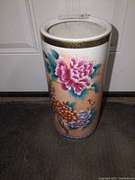 Full front view of the porcelain umbrella holder showing floral design and gold trim.