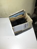 View of the box containing the black plastic View-Master viewer with several viewing discs visible upright inside, including one labeled 'White Mountains'.