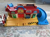 Fisher-Price Main Street playset showing market, firehouse, post office, and blue ramp slide