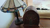 Full view of stained glass lamp with colorful accents and vintage wooden radio side by side