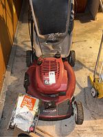 Front view of Toro red lawn mower with 22-inch deck and used grass collection bag, showing wear and dirt.
