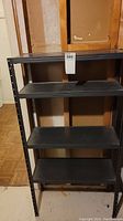 Front view of the metal shelving unit showing four shelves and sturdy frame.