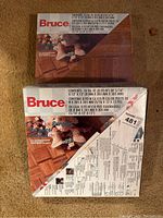 Two boxes of Bruce Oak Parquet Flooring stacked showing label with parquet pattern image.