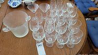 Full set of stemware glasses and the ice bucket on a wooden table.