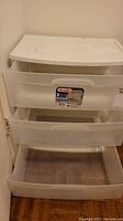 Front view of the white-top plastic storage bin with three semi-transparent drawers, showing the Sterilite label on the middle drawer.