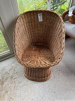 Front view of the wicker chair showing rounded back and seating area.