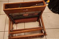 Front view of wooden loom frame with heddles and warp threads