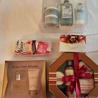 Full view of all items in the pampering lot including hair remover, perfume gift set, bath truffles, spice vanilla gift box, and yoga therapy bath set.