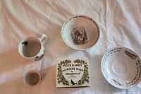 Photo showing mug, bowl, egg cup, and original Peter Rabbit Nursery Ware Wedgwood box on white cloth background.