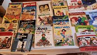 Photo showing a large assortment of Robert Munch children's books laid out in rows, displaying front covers with colorful illustrations