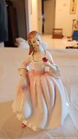 Front view of Royal Doulton Tender Moments figurine, showing woman in pink and white dress holding a rose.
