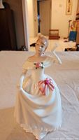 Front view of Royal Doulton Dawn figurine in white dress with pink bow and rose detail.