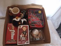 Boxed lot showing all items inside: mug, plush mascot, two bobbleheads in boxes, baseball in display case, and a Diamondbacks lunch bag.