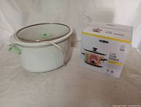 Photo showing large oval slow cooker next to boxed Bella 1.5 QT slow cooker.