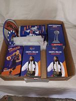 Collection of WNBA bobbleheads and fan gear boxed, showing player images and collector's items.
