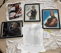 Four autographed StarGate related framed photos displayed on a lace tablecloth.