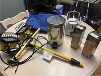 Overview of entire lot on table including glasses, spot lights, toaster, can, and duffel bag