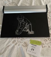 Top view of the black laser cut sign with silver Gollum image and attached silver light frame.