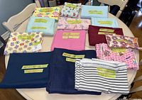 Images showing various new fabric pieces neatly folded with size labels on tape.