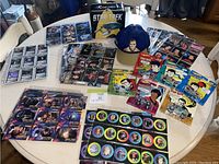 Overall display of Star Trek trading cards, Hot Wheels cars, and cap on table