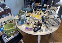 Full overview of all Star Wars toys and collectibles spread on a round white table with chairs, various Star Wars spaceships, figures, and accessories included.
