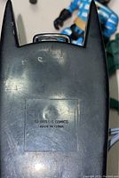 Close-up photo of the back of a Batman figure showing a stamped mark indicating the year 1995 and DC Comics branding, made in China.