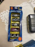 Boxed set of 5 miniature cars named 'Ruff 'n' Tuff' showing silver and purple cars in blue packaging.