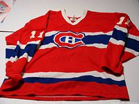 Front view of red Montreal Canadiens hockey jersey with number 11 and CH logo on chest, laid flat.