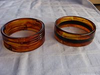 Both vintage Lucite bangles displayed on cloth background, showing size and color contrast.