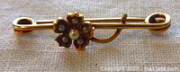 Front view of antique yellow gold flower pin with seed pearls, showing the flower design and pearls.