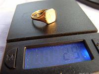 Signet ring placed on a scale showing approximate weight of 2.9 grams.