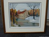 Framed view of the oil painting showing the mill and river with fall and winter scenery.