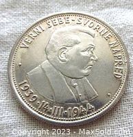 Obverse side of Slovenska silver commemorative coin showing a profile portrait of a man with inscriptions and anniversary dates.