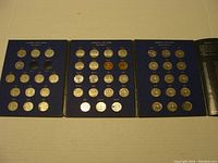 Two coin books laid flat opened, showing multiple Canadian nickels arranged by year and type.