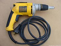 Yellow and black Dewalt cordless drywall screwdriver with attached power cord, showing overall tool layout and condition.