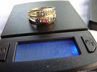 Top view of the 10K white gold multi-stone ring on a weight scale showing 3.9 grams.