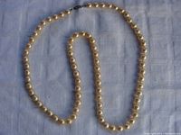 Full length of the pearl necklace arranged in a loose loop to show the pearls and overall appearance.