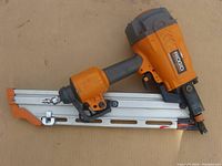 Side view of orange and gray Ridgid framing nailer showing overall condition