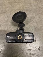 Front view of Snood LS400W car dash camera showing camera lens, logos, and suction cup mount.