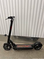 Full side profile of GB Tiger electric scooter showing frame, wheels and deck